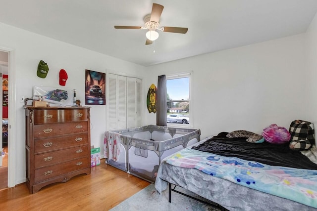 bedroom with a ceiling fan, light wood-style floors, and a closet