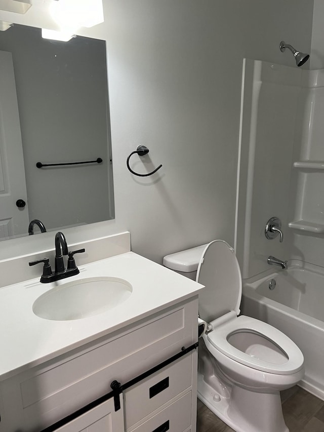 full bathroom featuring toilet, vanity, wood finished floors, and shower / tub combination