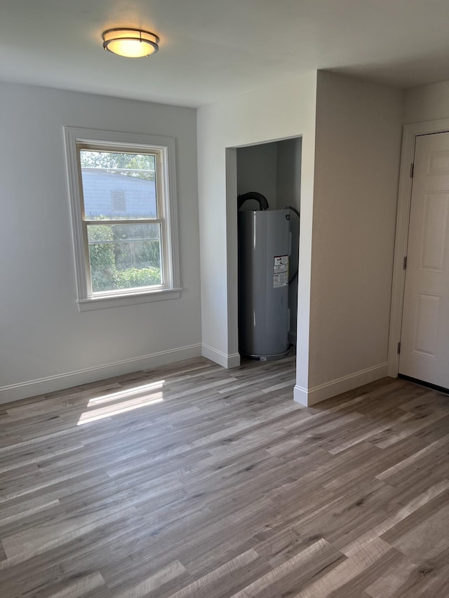 interior space featuring wood finished floors, baseboards, and electric water heater
