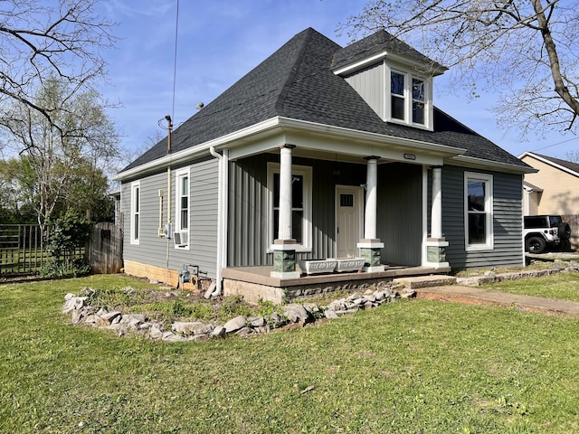 bungalow with fence, a porch, cooling unit, a front yard, and roof with shingles
