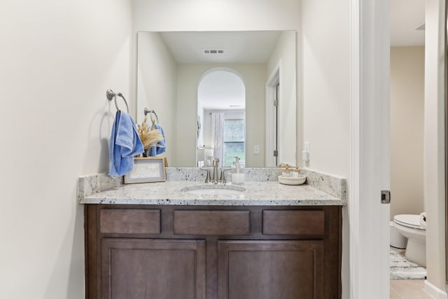bathroom featuring toilet, vanity, tile patterned floors, and visible vents