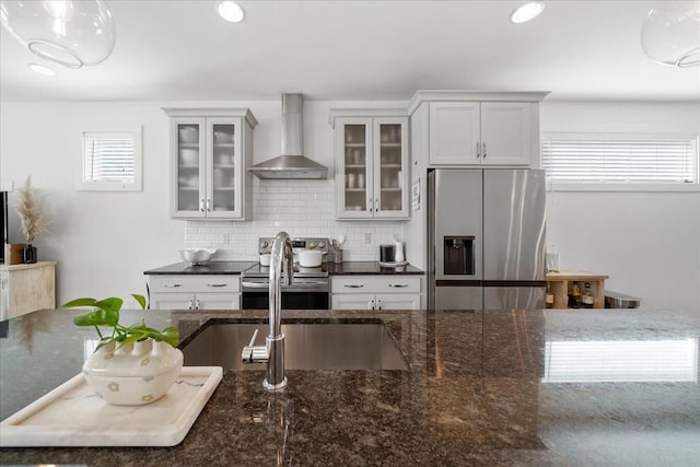 2123A 14th Ave N, Nashville, TN 37208 - kitchen featuring decorative backsplash, wall chimney exhaust hood, dark stone countertops, and stainless steel appliances