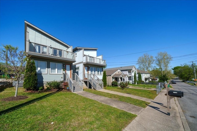 2123A 14th Ave N, Nashville, TN 37208 - view of front of home with board and batten siding, a front lawn, and a balcony