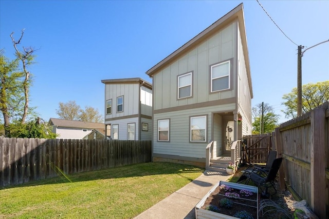 2123A 14th Ave N, Nashville, TN 37208 - rear view of house with board and batten siding, a fenced backyard, a vegetable garden, and a yard