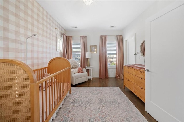 2123A 14th Ave N, Nashville, TN 37208 - living area with dark wood-type flooring, wallpapered walls, visible vents, and baseboards