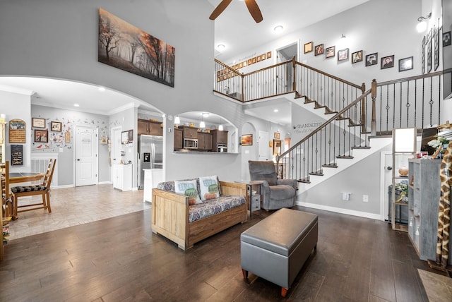 1438 Millet Dr, Clarksville, TN 37040 - living area with a ceiling fan, arched walkways, ornamental molding, stairway, and dark wood-style floors