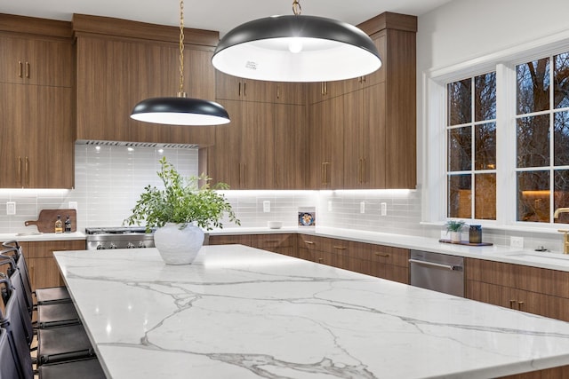 kitchen with light stone counters, dishwasher, modern cabinets, decorative backsplash, and brown cabinetry