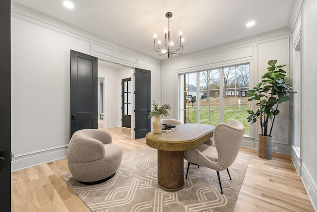 sitting room featuring recessed lighting, an inviting chandelier, light wood-style floors, and a decorative wall