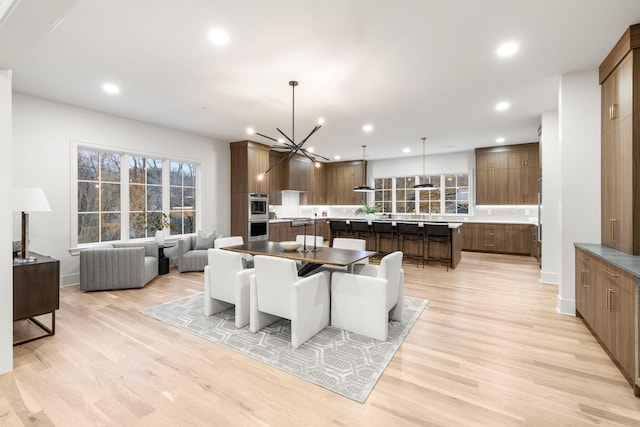dining space featuring a notable chandelier, light wood finished floors, and recessed lighting