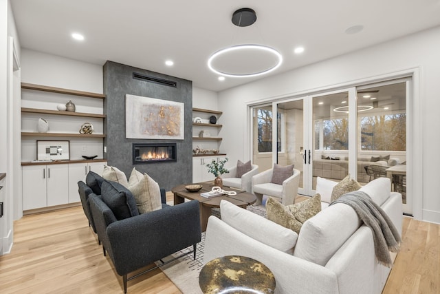living area featuring a large fireplace, light wood-style floors, and recessed lighting