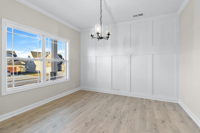 998 Alton Dr, Clarksville, TN 37043 - unfurnished dining area with visible vents, a decorative wall, crown molding, a chandelier, and light wood-style flooring