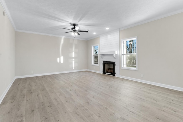 998 Alton Dr, Clarksville, TN 37043 - unfurnished living room featuring light wood-type flooring, a ceiling fan, a large fireplace, and ornamental molding