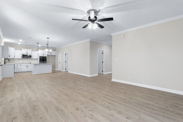 998 Alton Dr, Clarksville, TN 37043 - unfurnished living room with light wood finished floors, a sink, baseboards, ceiling fan with notable chandelier, and ornamental molding