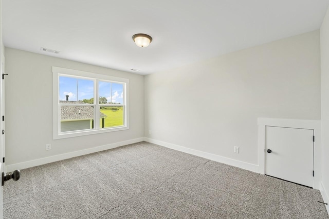 unfurnished room with baseboards, visible vents, and carpet