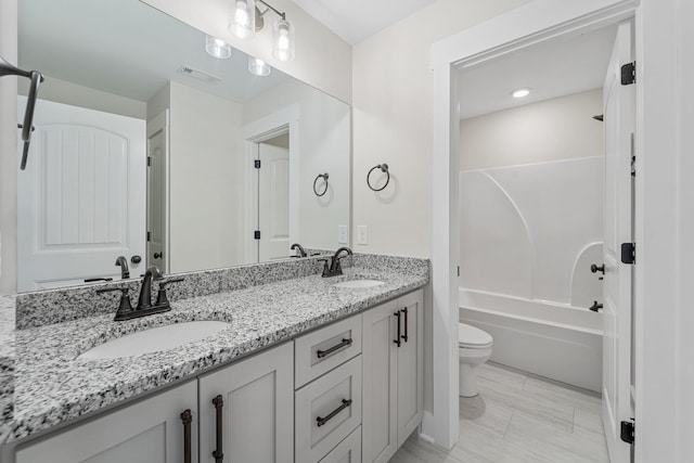 full bath with toilet, visible vents, a sink, and double vanity