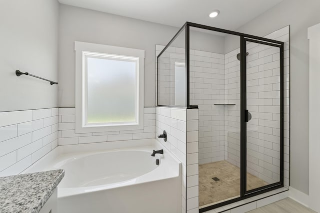 full bath with a garden tub, recessed lighting, and a stall shower