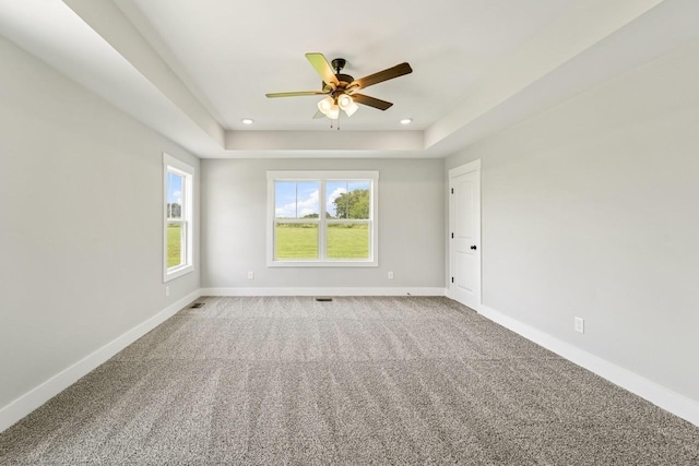 carpeted spare room featuring baseboards, recessed lighting, a raised ceiling, and ceiling fan