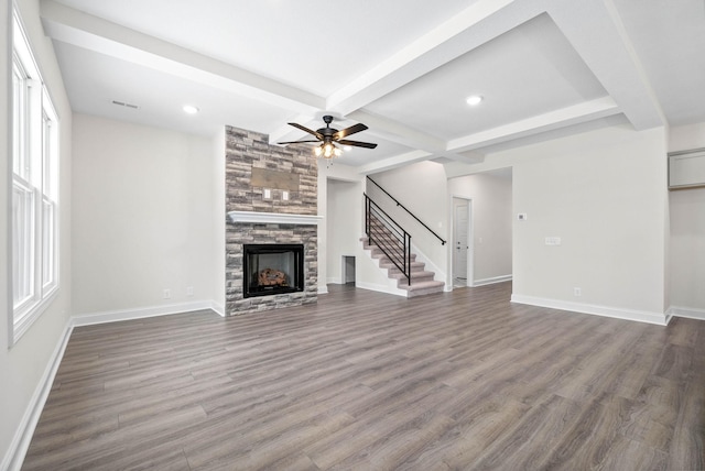 484 Herman Dr, Clarksville, TN 37042 - unfurnished living room featuring visible vents, beamed ceiling, stairs, a stone fireplace, and dark wood-type flooring