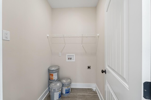 clothes washing area with hookup for a washing machine, baseboards, electric dryer hookup, and laundry area