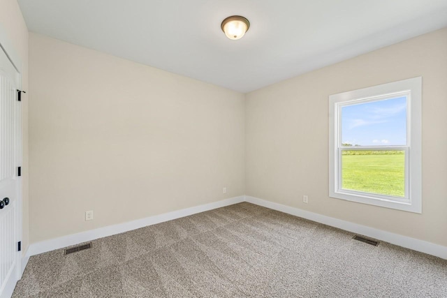 carpeted spare room with baseboards and visible vents