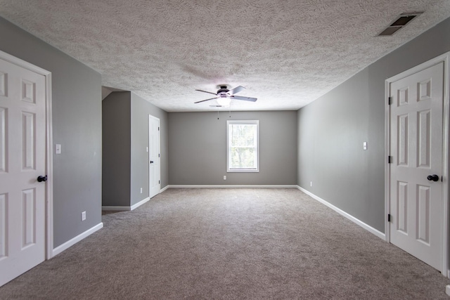 spare room featuring baseboards, a ceiling fan, visible vents, and carpet floors