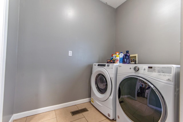 laundry area featuring separate washer and dryer, light tile patterned floors, laundry area, baseboards, and visible vents