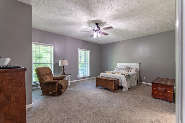 carpeted bedroom featuring a ceiling fan, baseboards, and a textured ceiling