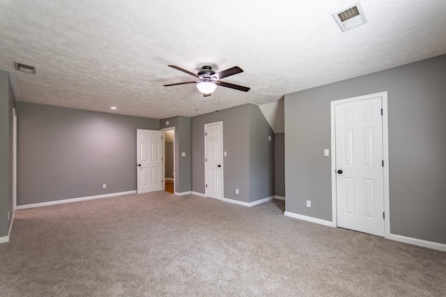 interior space with a textured ceiling, visible vents, a ceiling fan, and baseboards