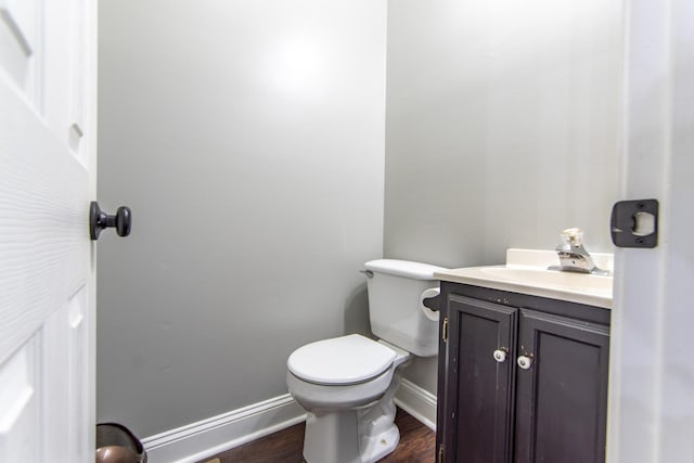 bathroom featuring baseboards, toilet, vanity, and wood finished floors
