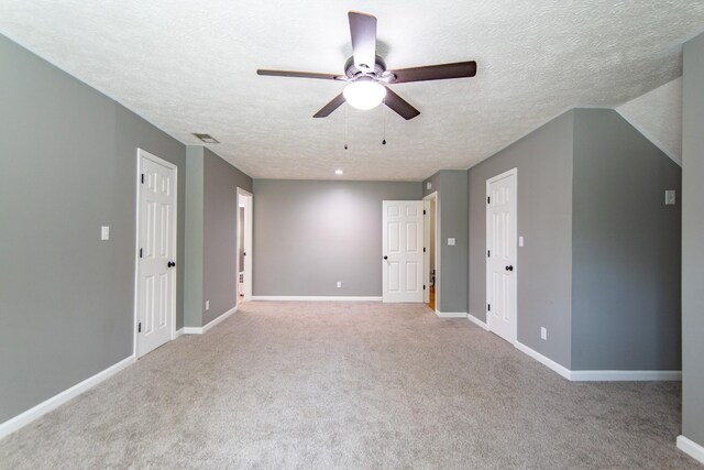 spare room with carpet floors, a textured ceiling, baseboards, and ceiling fan