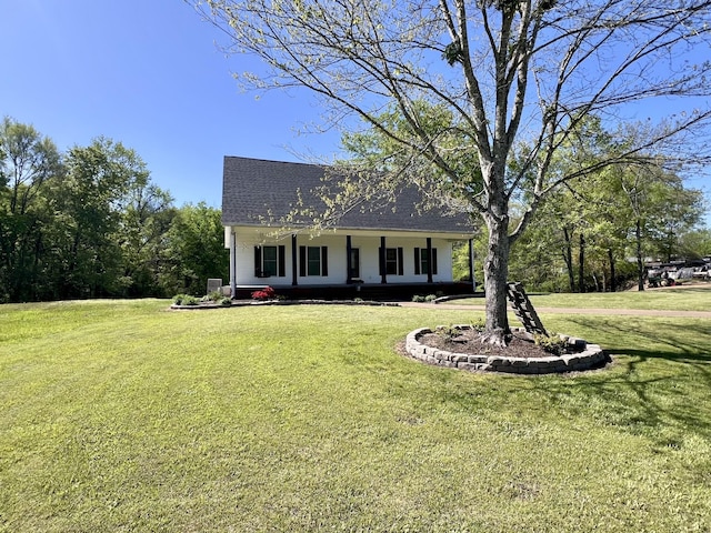 view of front of property featuring covered porch, a shingled roof, and a front yard