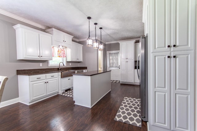 kitchen with white cabinets, dark countertops, and a kitchen island