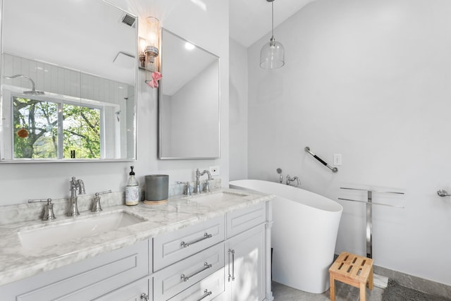 full bath with a freestanding tub, a sink, visible vents, and double vanity