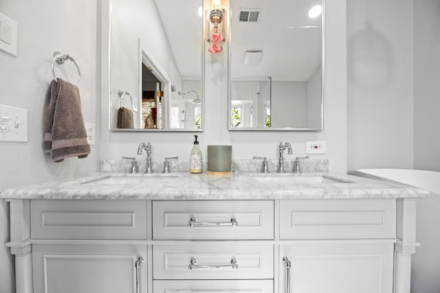 bathroom featuring double vanity, visible vents, and a sink