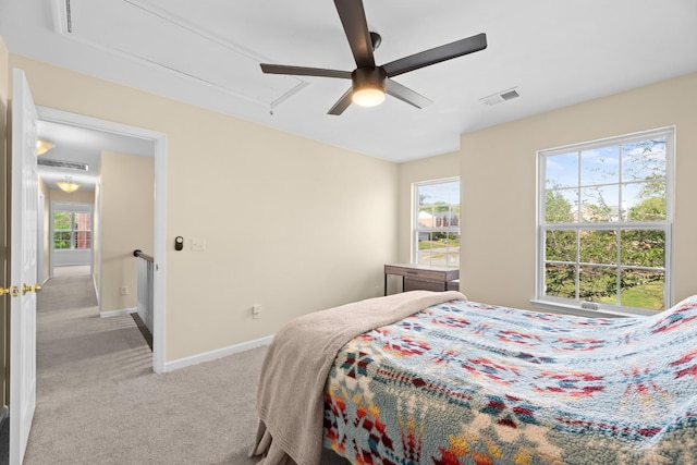 carpeted bedroom with attic access, baseboards, multiple windows, and visible vents
