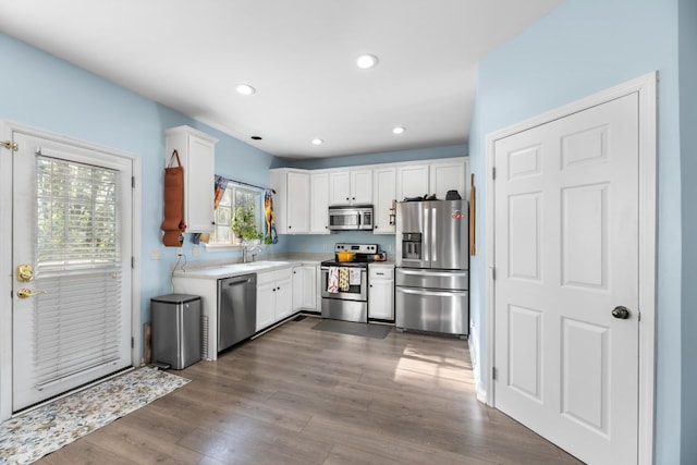 kitchen featuring a sink, white cabinetry, appliances with stainless steel finishes, dark wood-style floors, and recessed lighting