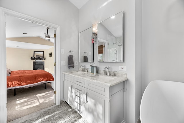 ensuite bathroom featuring lofted ceiling, ensuite bathroom, and a sink