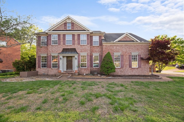 colonial-style house with brick siding and a front yard