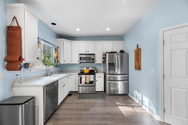 kitchen featuring dark wood-style floors, a sink, recessed lighting, white cabinetry, and appliances with stainless steel finishes