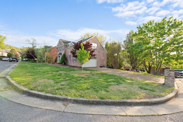 view of side of property featuring driveway, brick siding, and a yard