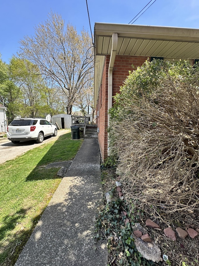 view of property exterior with brick siding and a yard