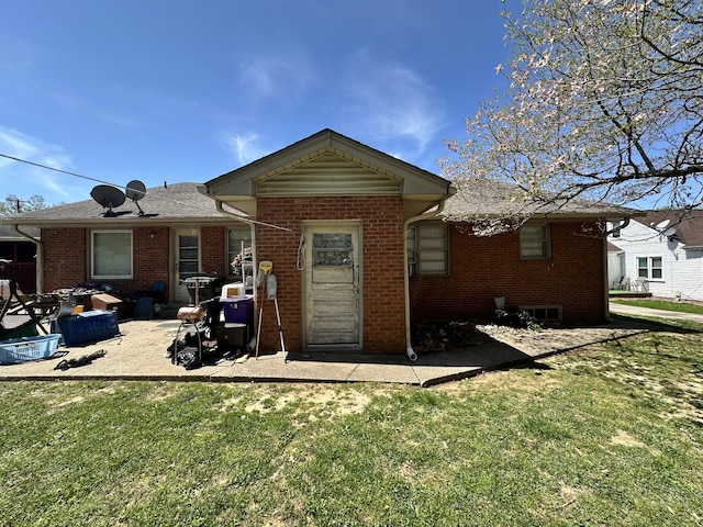 rear view of house featuring brick siding and a lawn