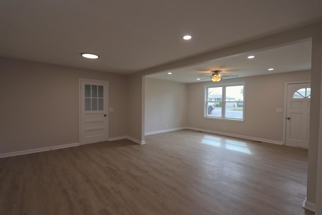 unfurnished room with baseboards, wood finished floors, and a healthy amount of sunlight