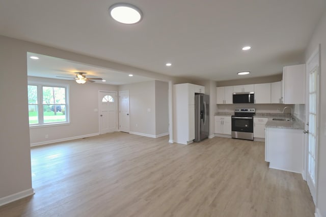 kitchen featuring appliances with stainless steel finishes, open floor plan, recessed lighting, and light wood-style flooring