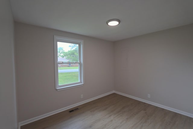 empty room featuring visible vents, baseboards, and light wood-style floors