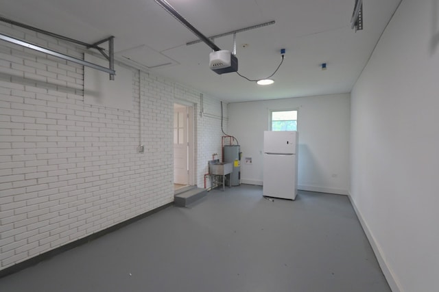 garage featuring baseboards, a garage door opener, water heater, and freestanding refrigerator