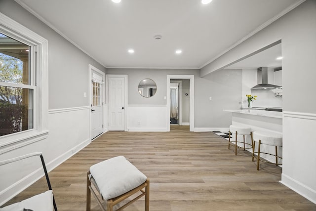 sitting room with light wood-type flooring, baseboards, recessed lighting, and ornamental molding