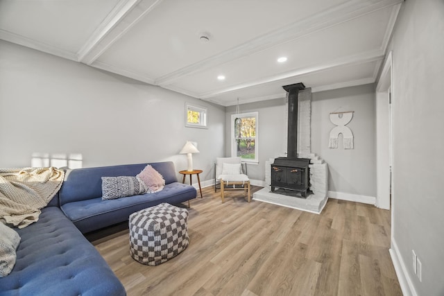 living room featuring baseboards, recessed lighting, beamed ceiling, wood finished floors, and a wood stove