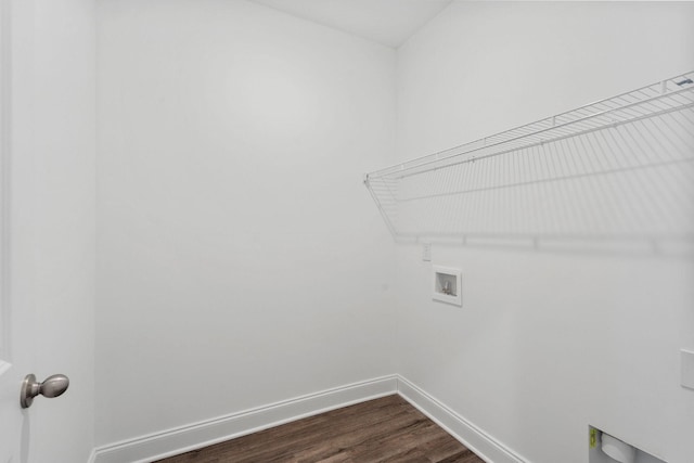 washroom with dark wood finished floors, baseboards, hookup for a washing machine, and laundry area