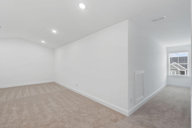 additional living space with vaulted ceiling, light carpet, baseboards, visible vents, and recessed lighting